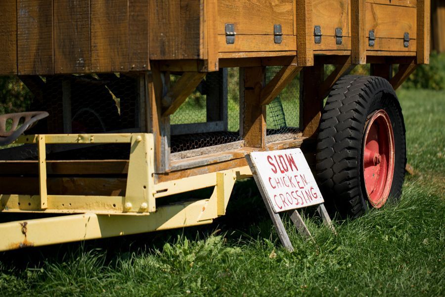 Chicken coop trailer with a “Slow Chicken Crossing” sign at Isham Family Farm.