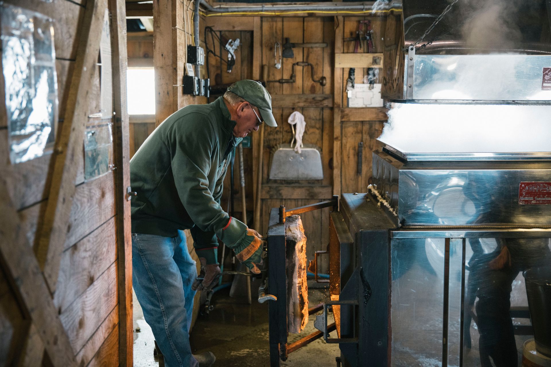 Isham family member stoking the fire during the maple boiling process