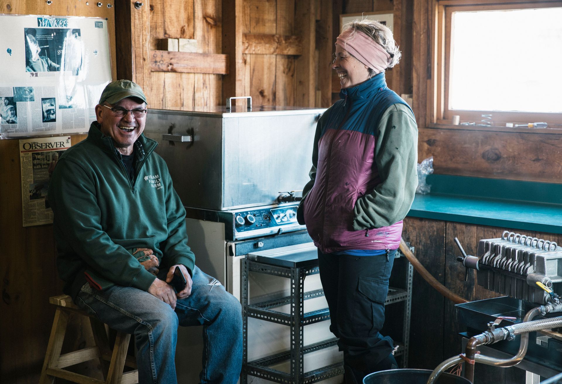 Sugarmakers sharing a laugh inside the sugarhouse at Isham Family Farm in Vermont during maple syrup season.