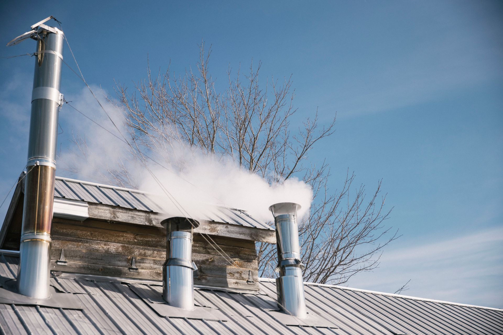 close up of the isham family farm maple production shack, blowing out steam from the maple boiling process