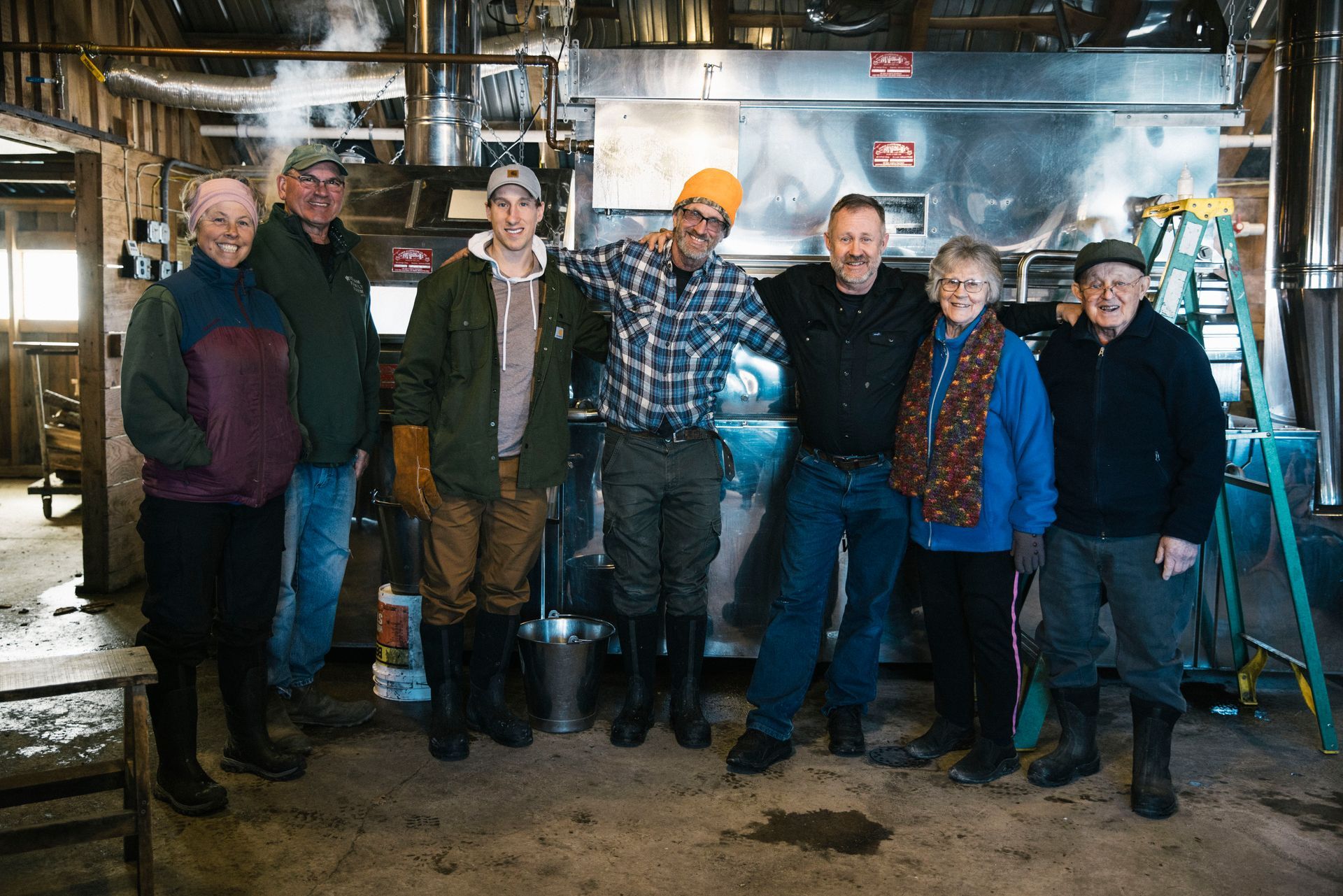Isham family members stand together in the sugarhouse during maple syrup season.