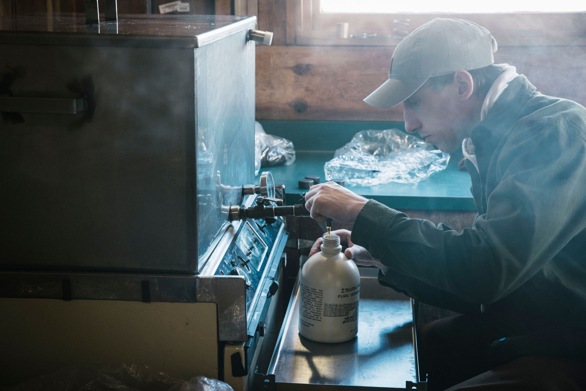 isham family member filling maple syrup containers for sale