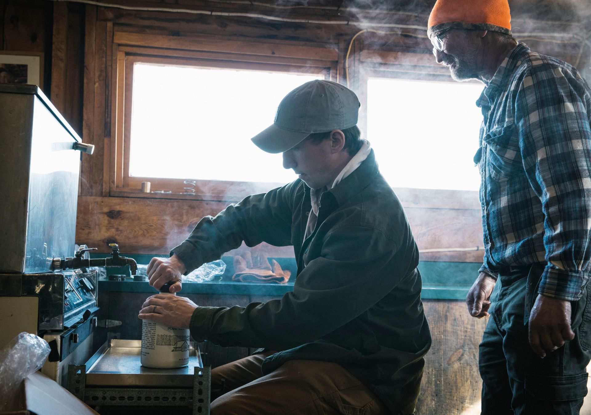 Capping a jug of hot maple syrup at Isham Family Farm's sugarhouse.