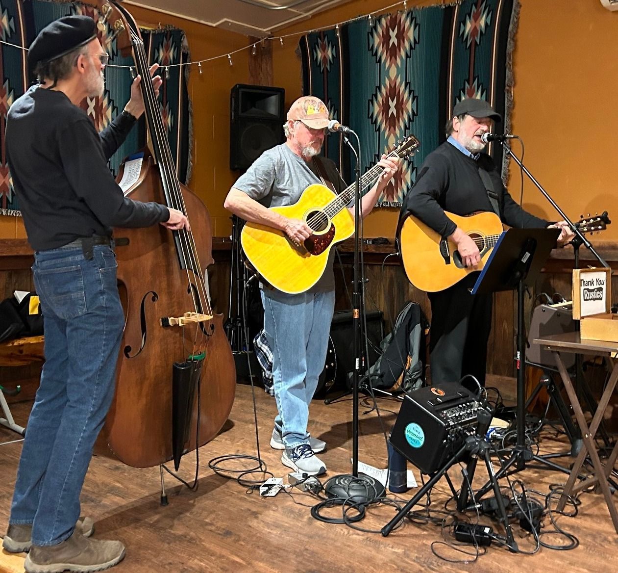 The rustics, acoustic trio, performing on stage in the events barn at isham family farm