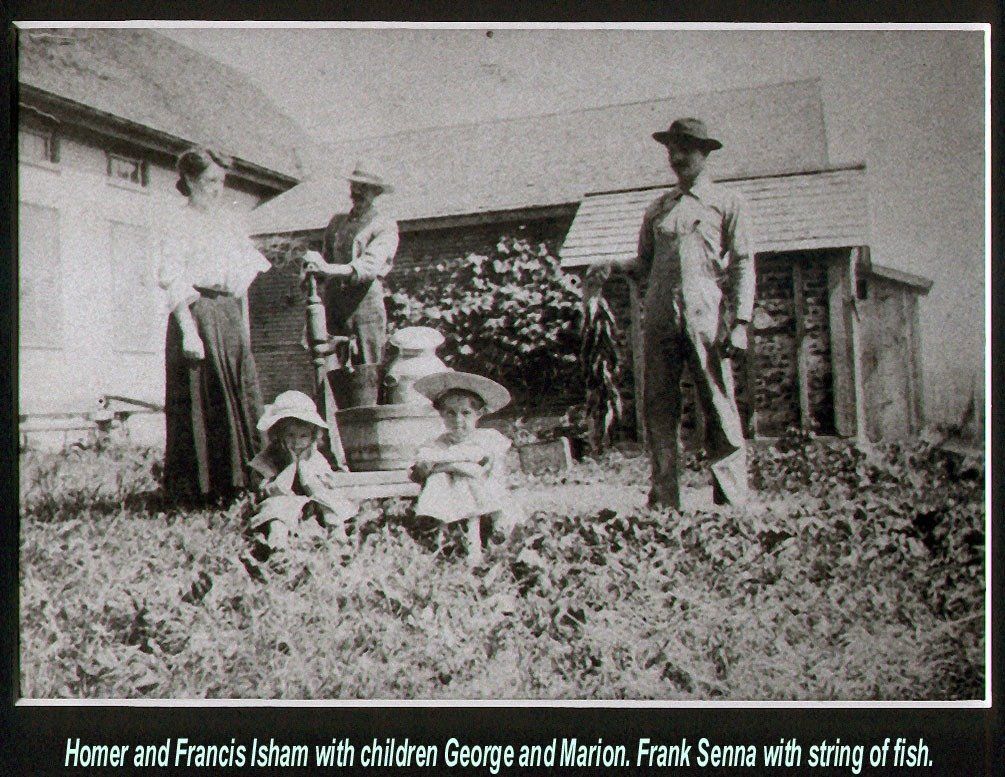 A vintage photo of Homer and Francis Isham with children George and Marion, alongside Frank Senna with a string of fish.