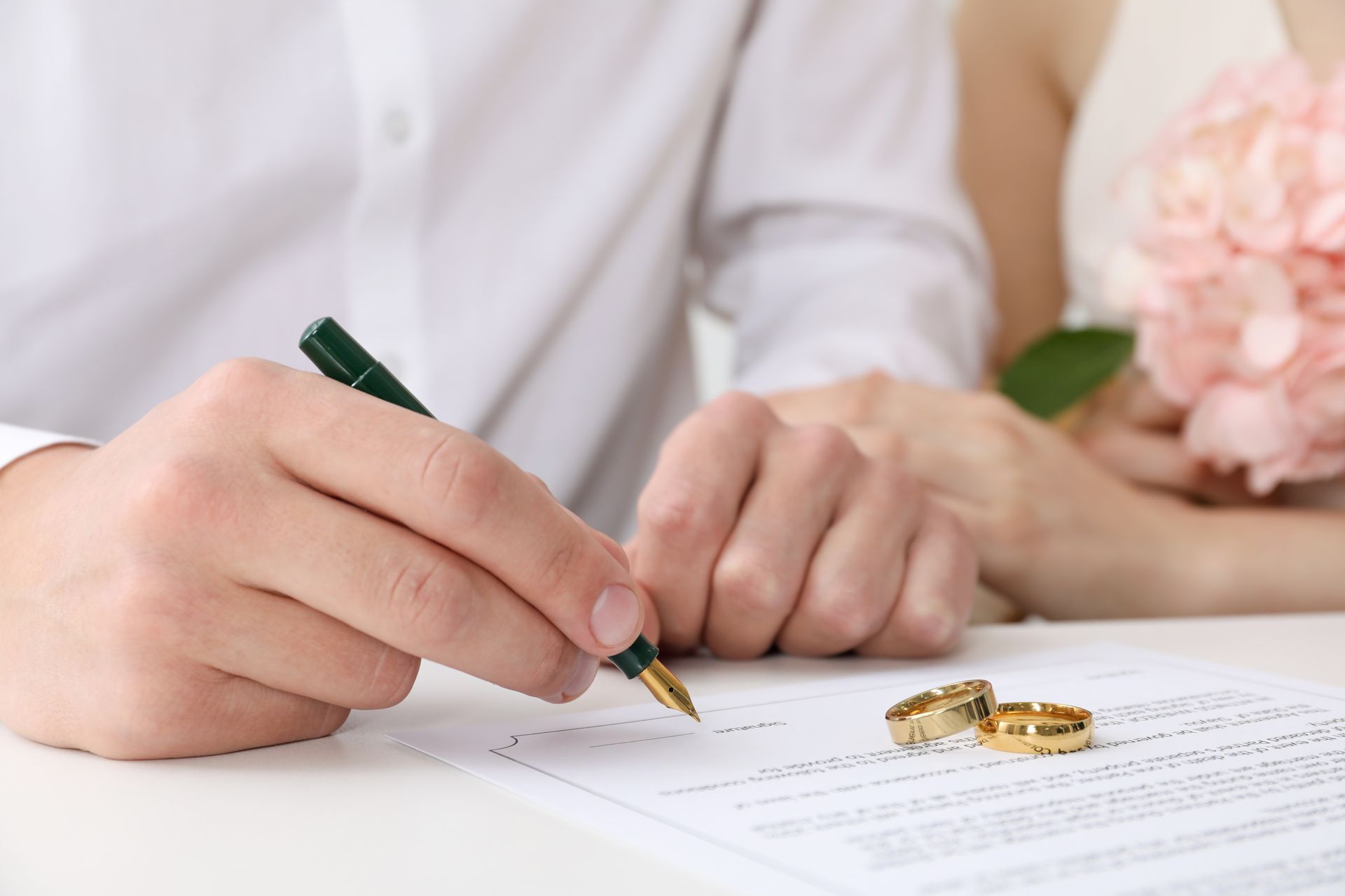 close up image of a couple signing their marriage license. 