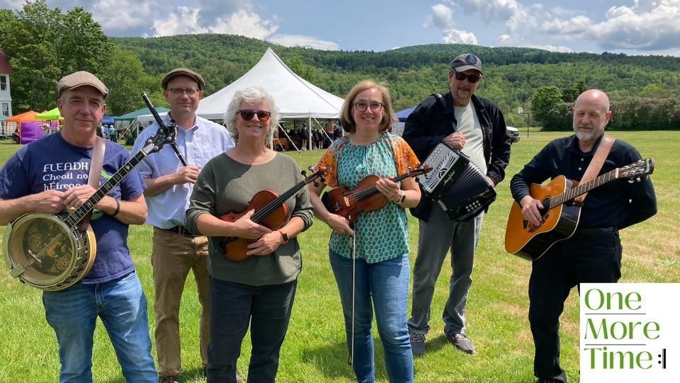 Folk band One More Time standing in front of the tents at isham family farm ahead of a performance.