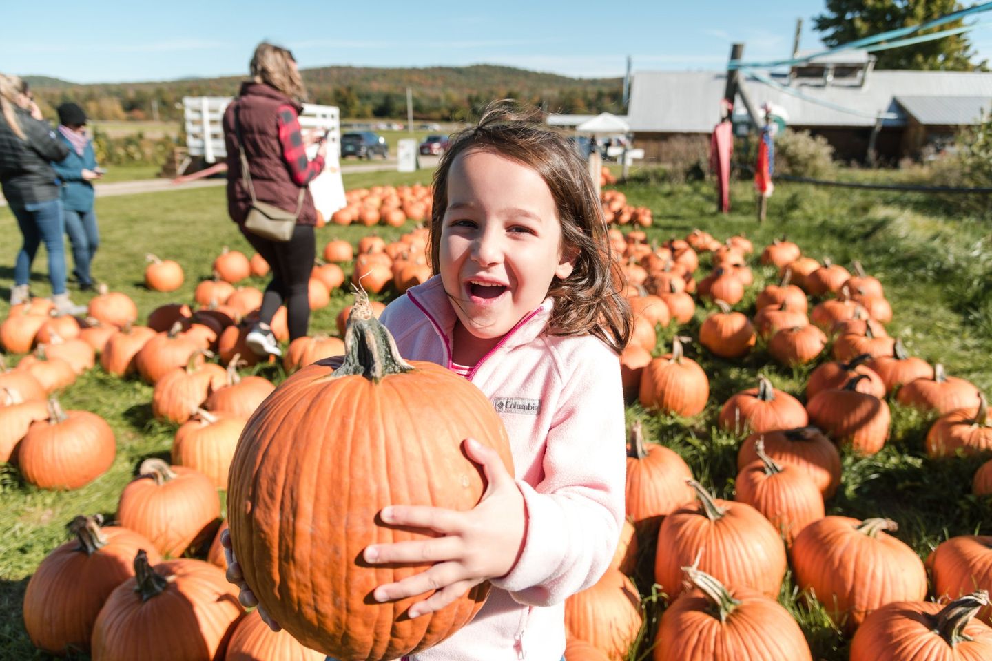 child holding a huge pumpkin that was picked personally at the Isham Family Farm Pumpkin Patch