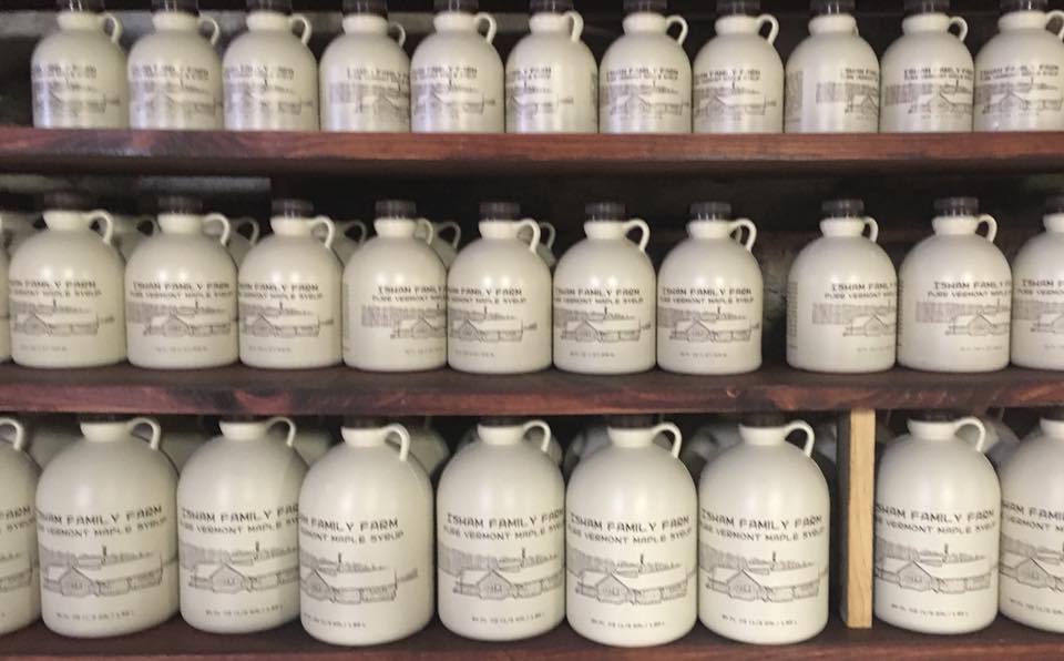 Photo of shelves holding various sized jugs of Vermont Maple Syrup