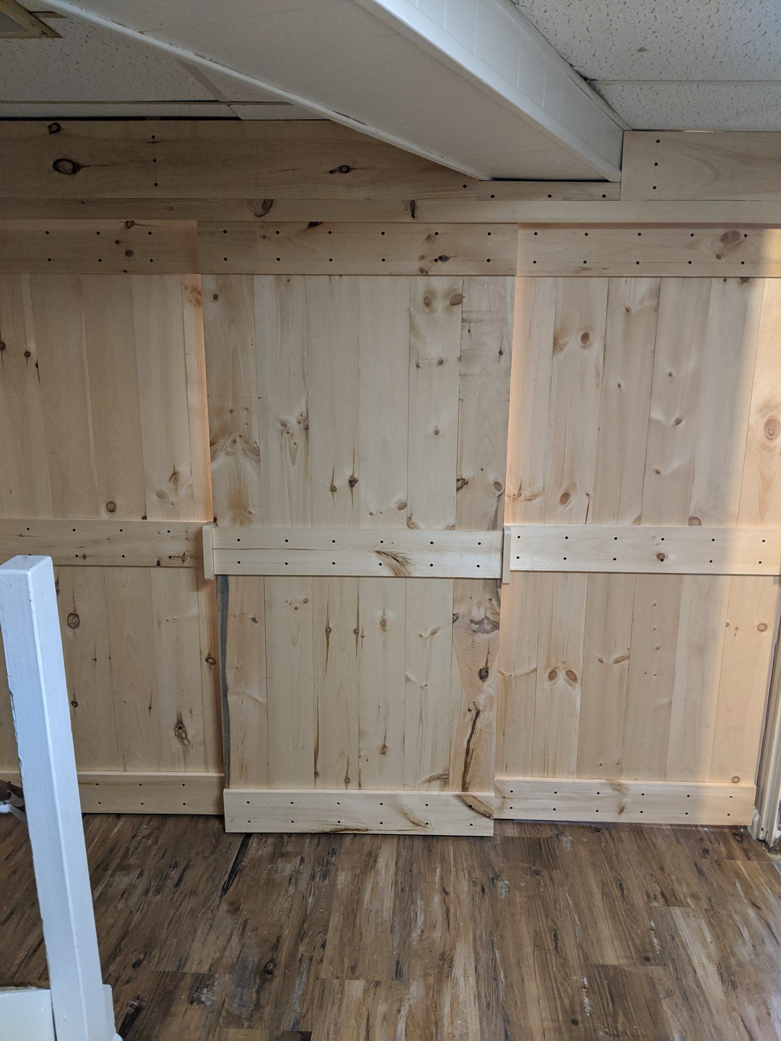 Wooden wall paneling with horizontal supports, installed on a wall.