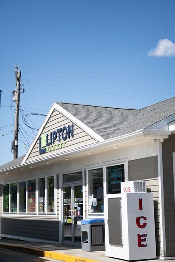 Lipton Market store front with white and gray exterior, blue sky, and