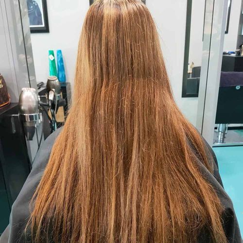 A Woman With Long Hair Is Sitting In A Chair In A Salon — MLB Hair In  Smithfield, QLD