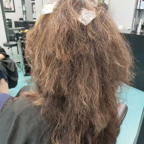 A Woman Is Getting Her Hair Done In A Salon — MLB Hair In  Smithfield, QLD