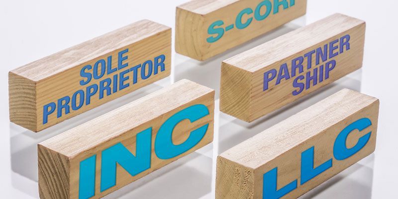 A group of wooden blocks with the words sole proprietor , partner ship , inc , and llc written on them.