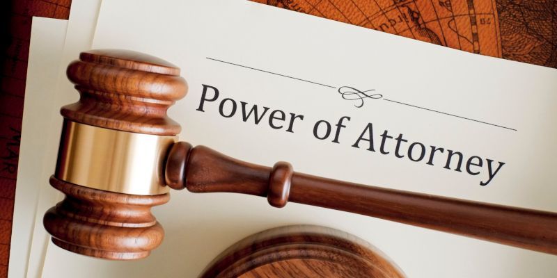 A wooden gavel is sitting on top of a power of attorney