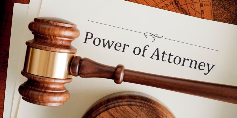 A wooden gavel is sitting on top of a power of attorney