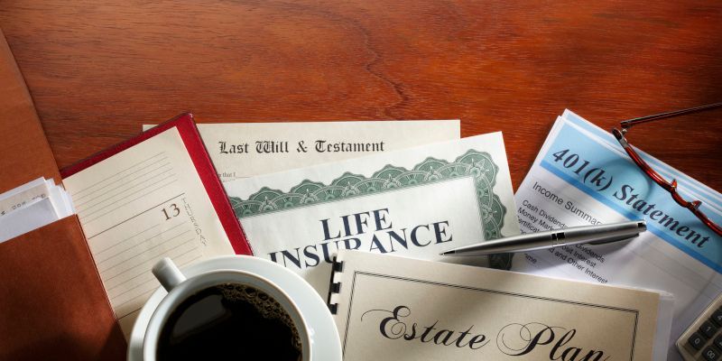 A cup of coffee is sitting on a table next to a life insurance certificate and an estate plan