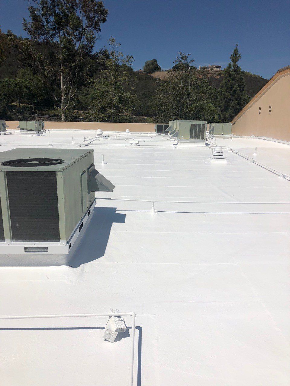 A white roof with an air conditioner on top of it.