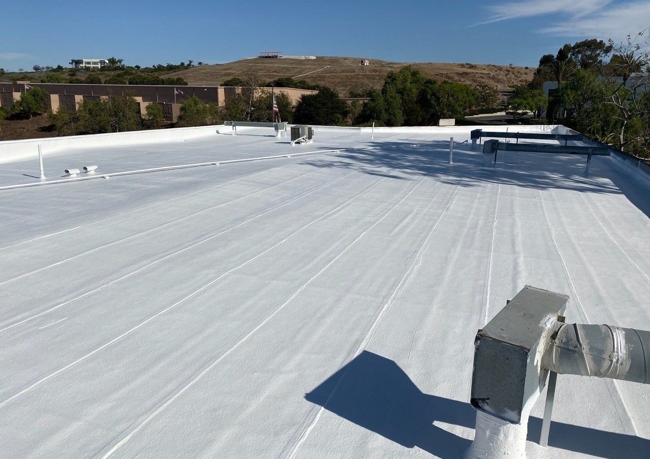 A white roof with a few trees in the background