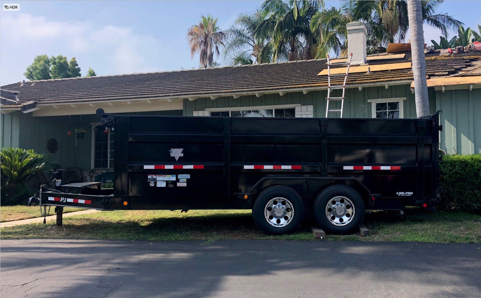 A dumpster trailer is parked in front of a house.