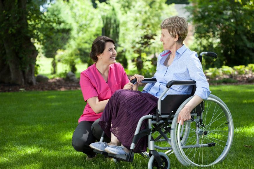 assistenza di una donna anziana in sedia a rotelle