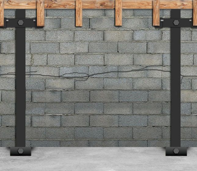 Gray cinder block wall with a horizontal crack, framed by dark posts and wood braces at the top.