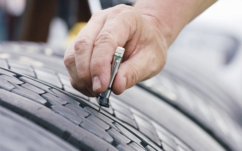 A close up of a tire with a patch on it.