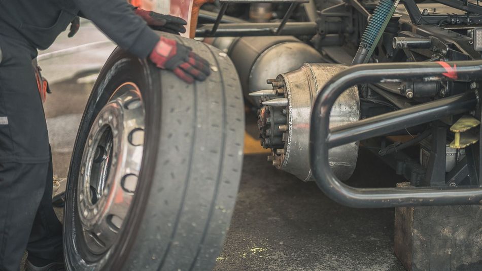 A car with a broken tire and a wrench on the ground.