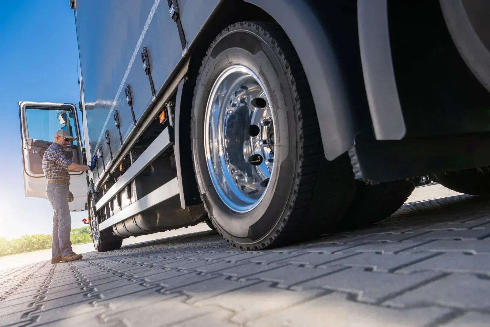 A man is standing next to a semi truck.