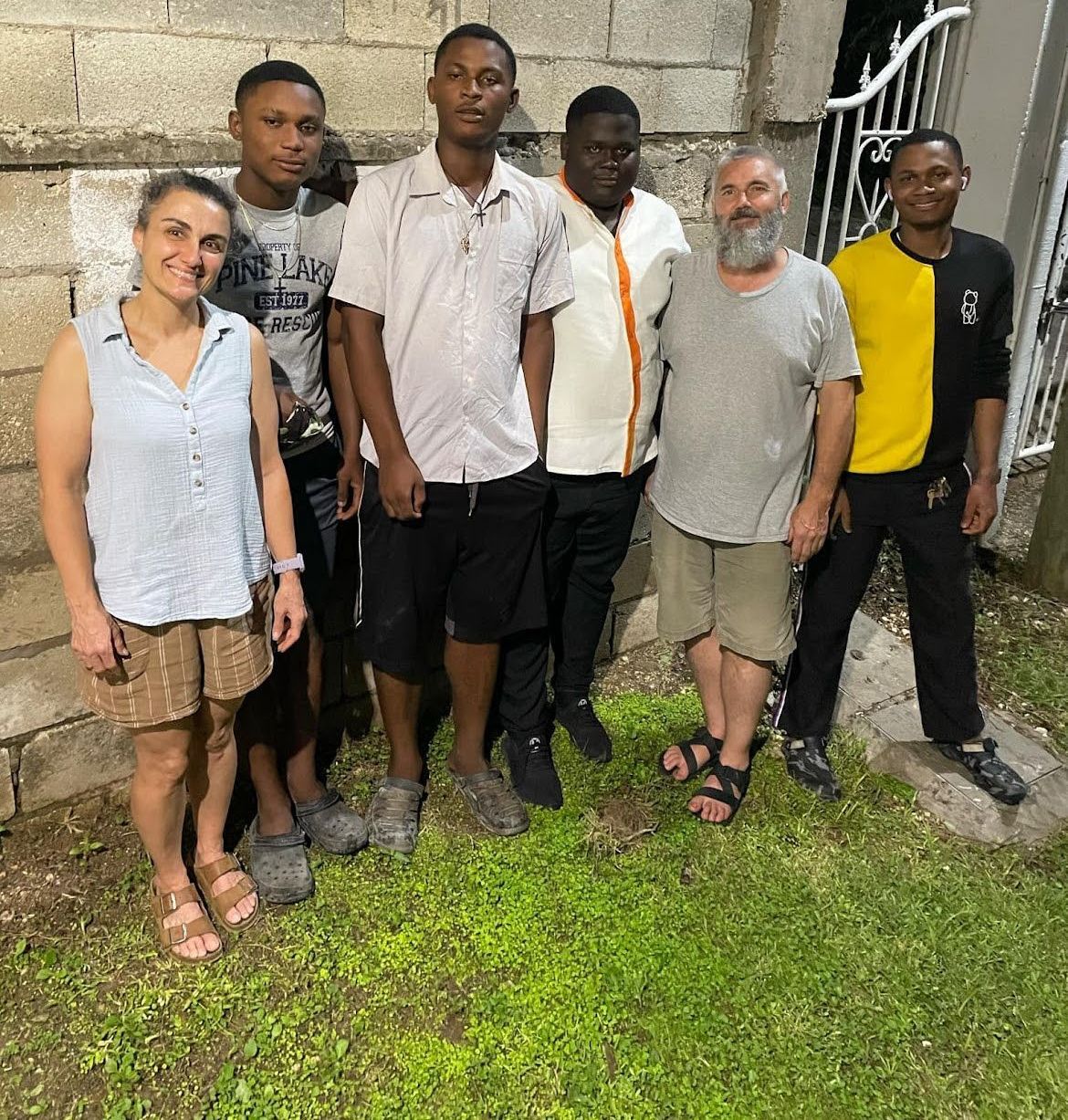 A group of people are posing for a picture in the grass