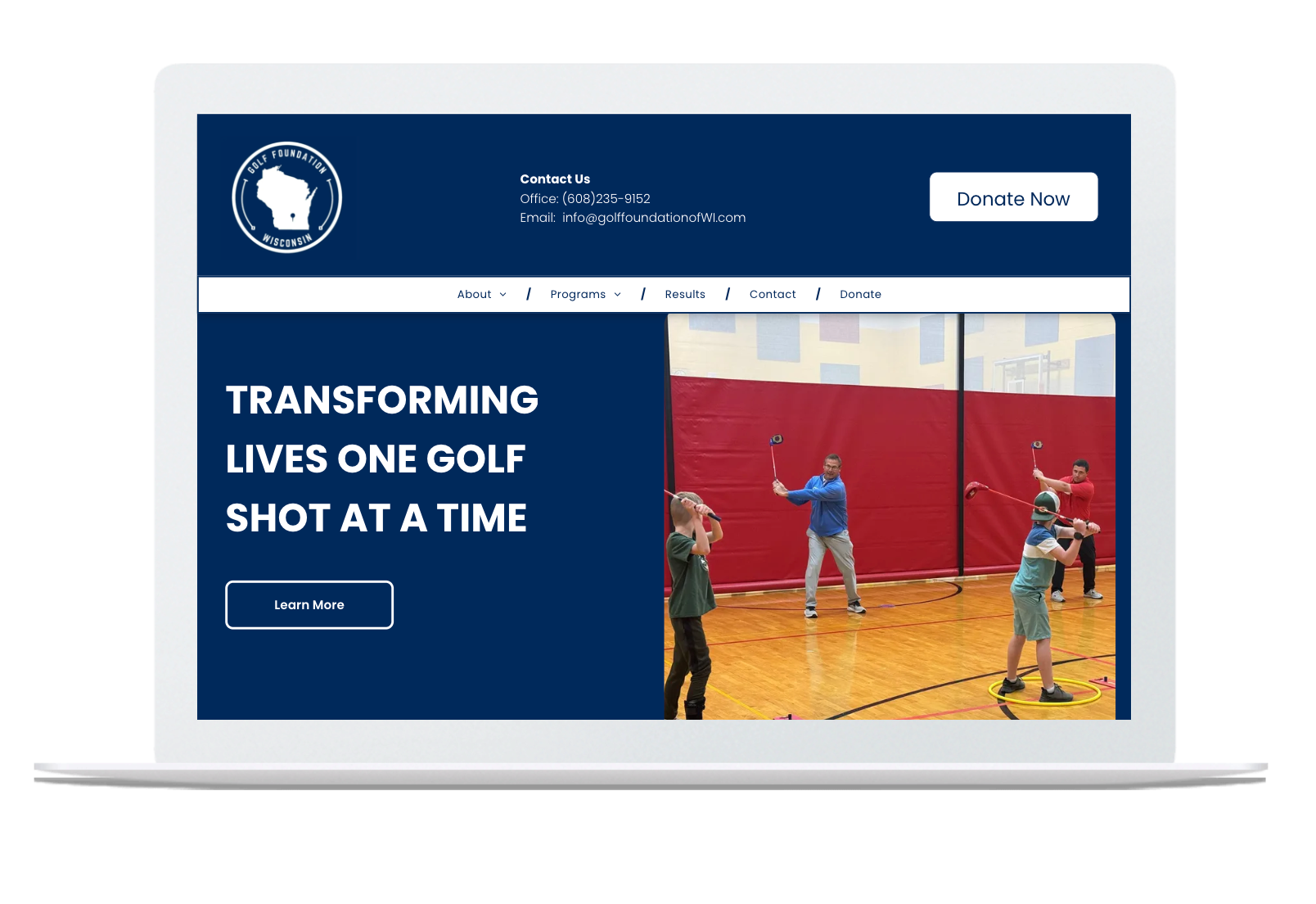 A laptop is open to a website that says `` transforming lives one golf shot at a time ''.