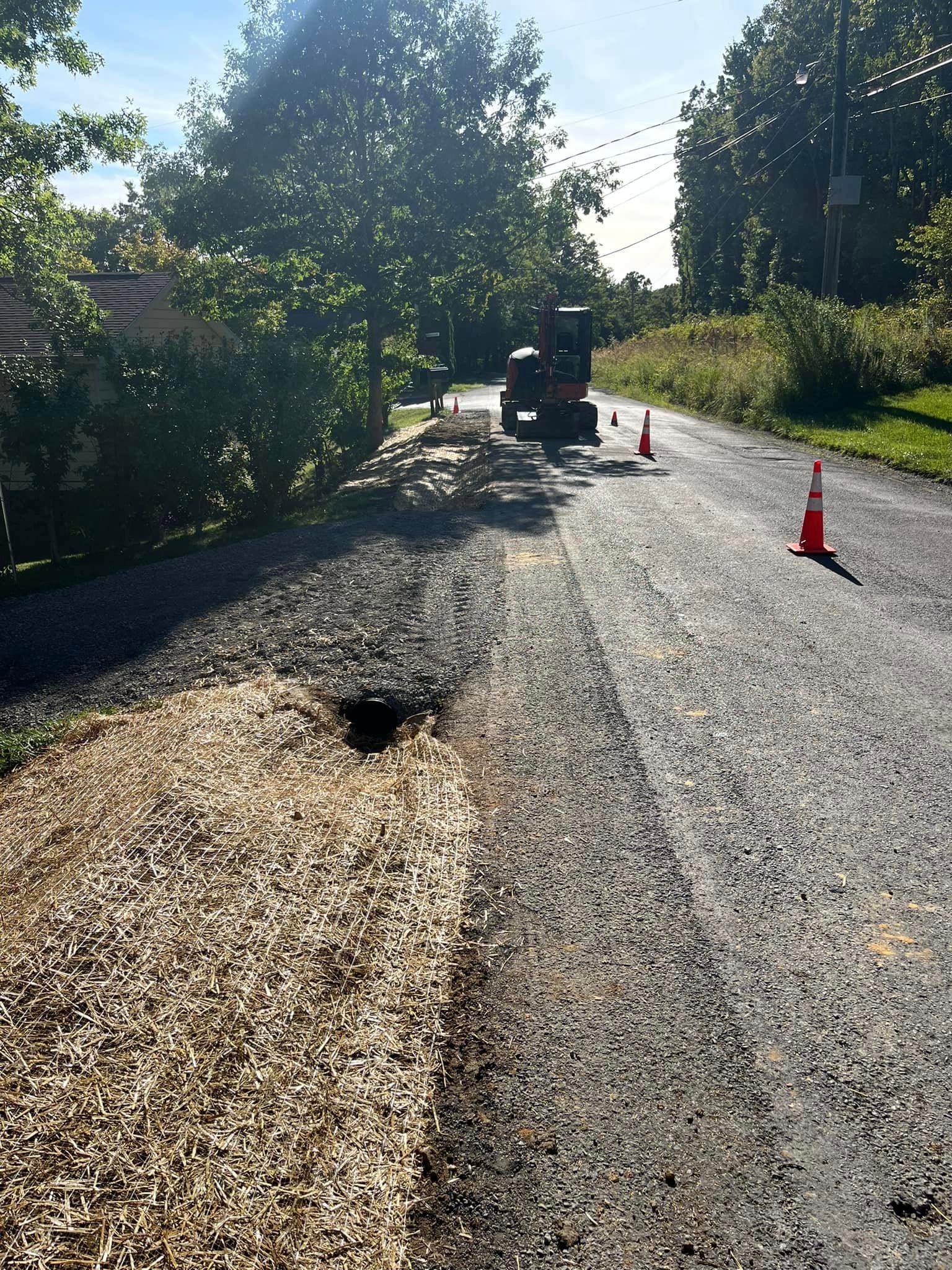 A tractor is driving down a road with a hole in the middle of it.