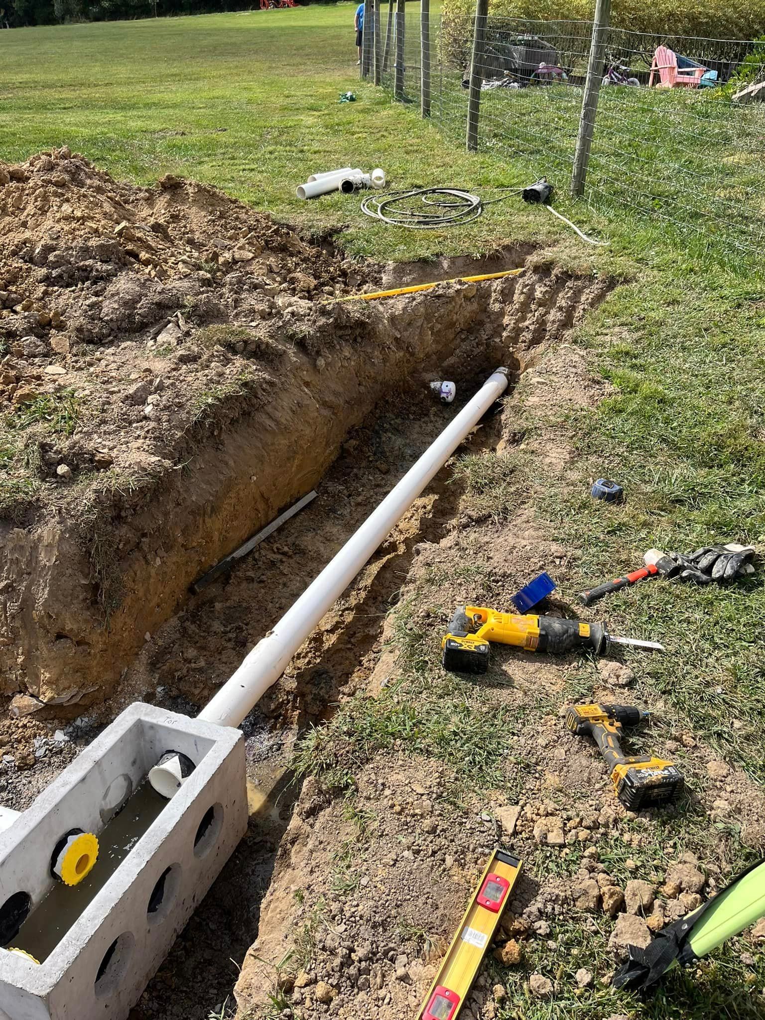 A pipe is being installed in a hole in the ground.