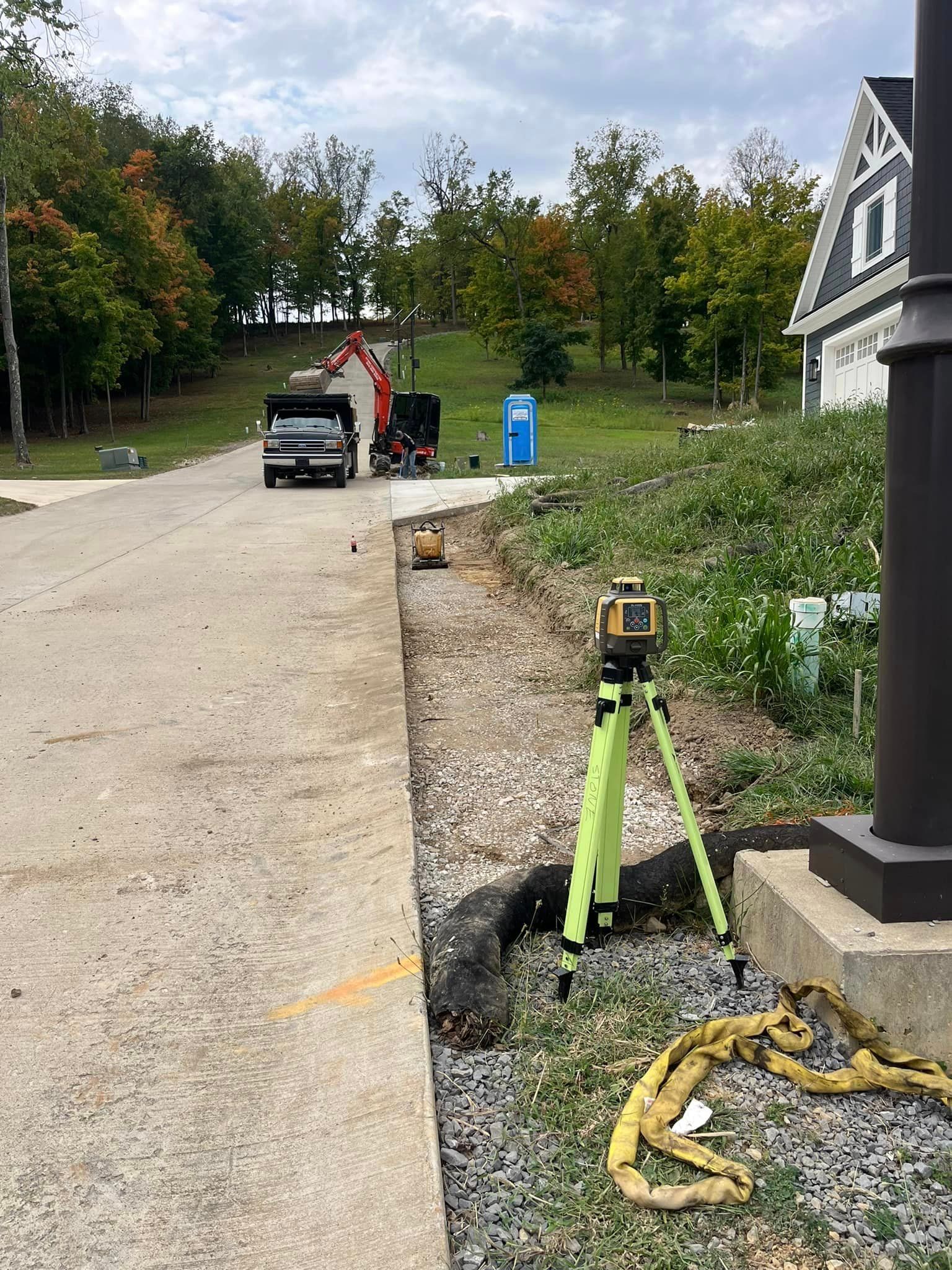 A truck is parked on the side of the road next to a tripod.