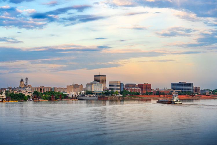 A large body of water with a city in the background and a boat in the foreground.
