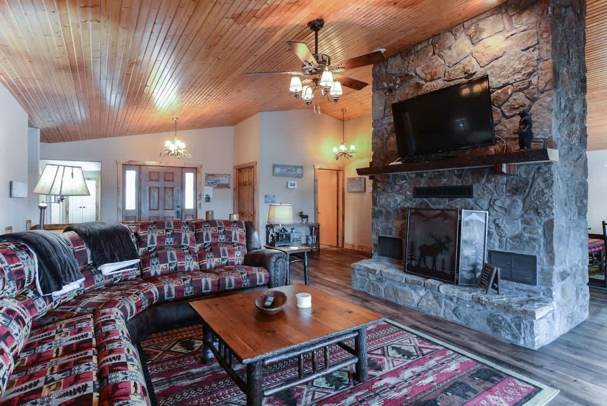 A living room with a fireplace , couch , coffee table and television.