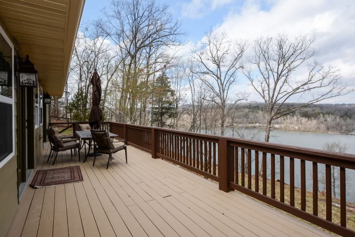 A large deck with a view of a lake and trees.
