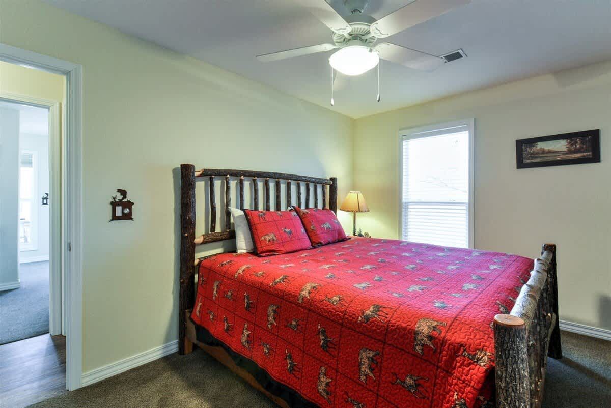 A bedroom with a king size bed and a ceiling fan.