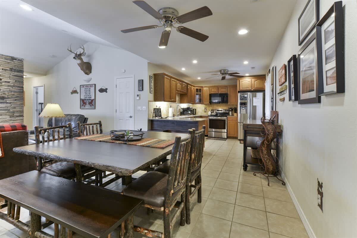 A dining room table and chairs in a house with a ceiling fan.