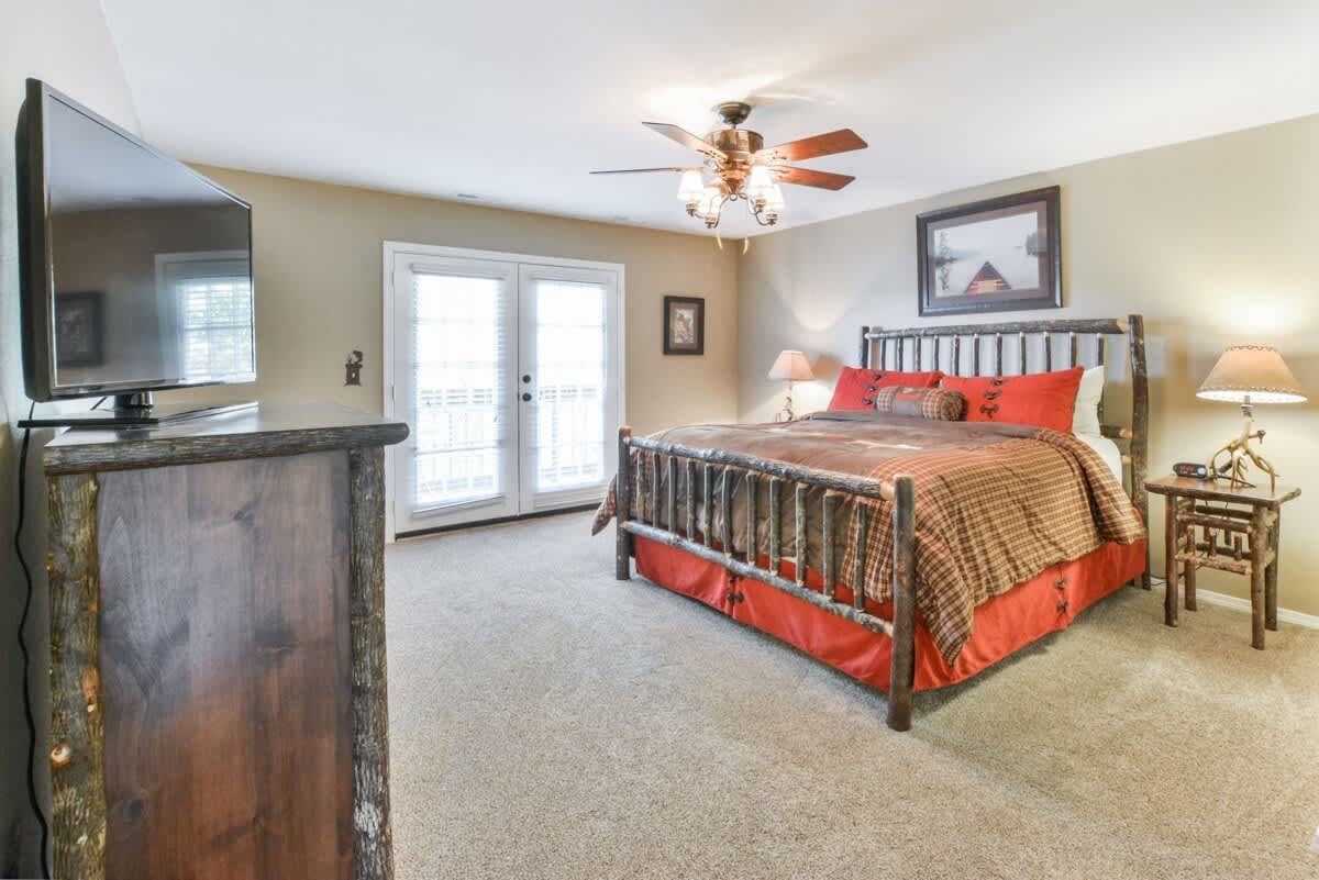A bedroom with a king size bed and a flat screen tv