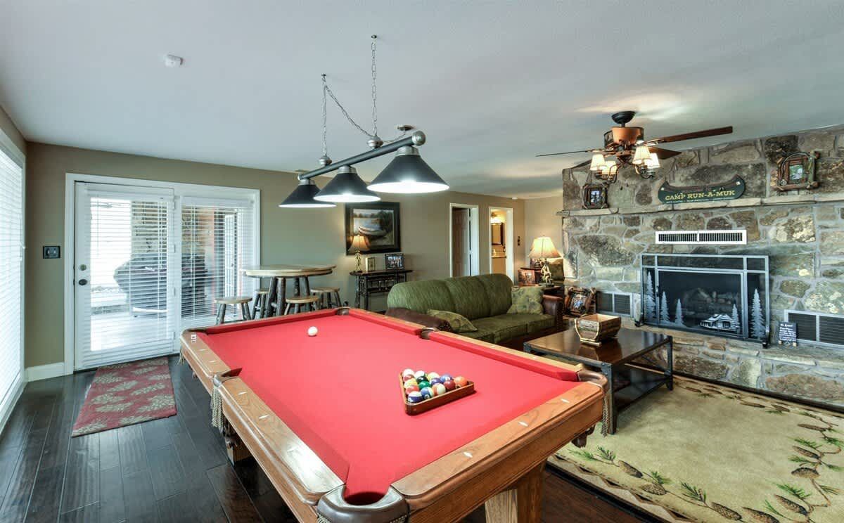 A pool table in a living room with a fireplace