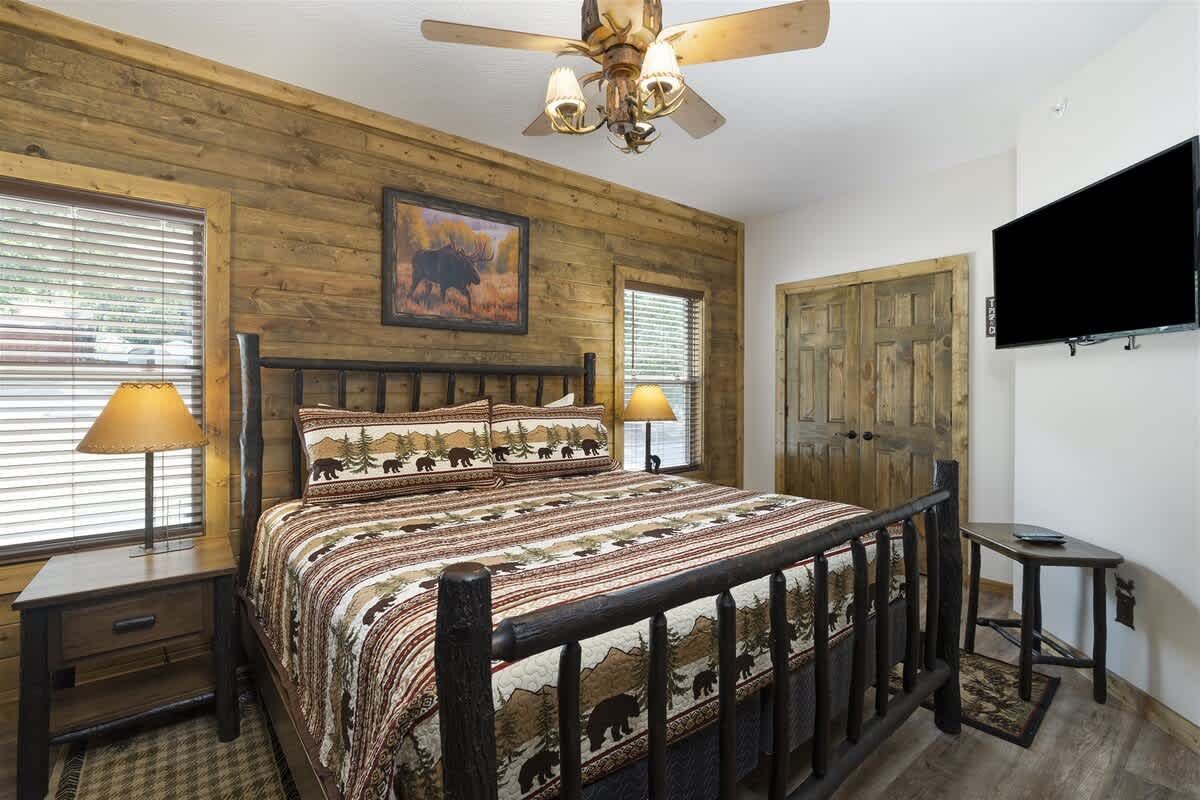 A bedroom with a king size bed and a flat screen tv.