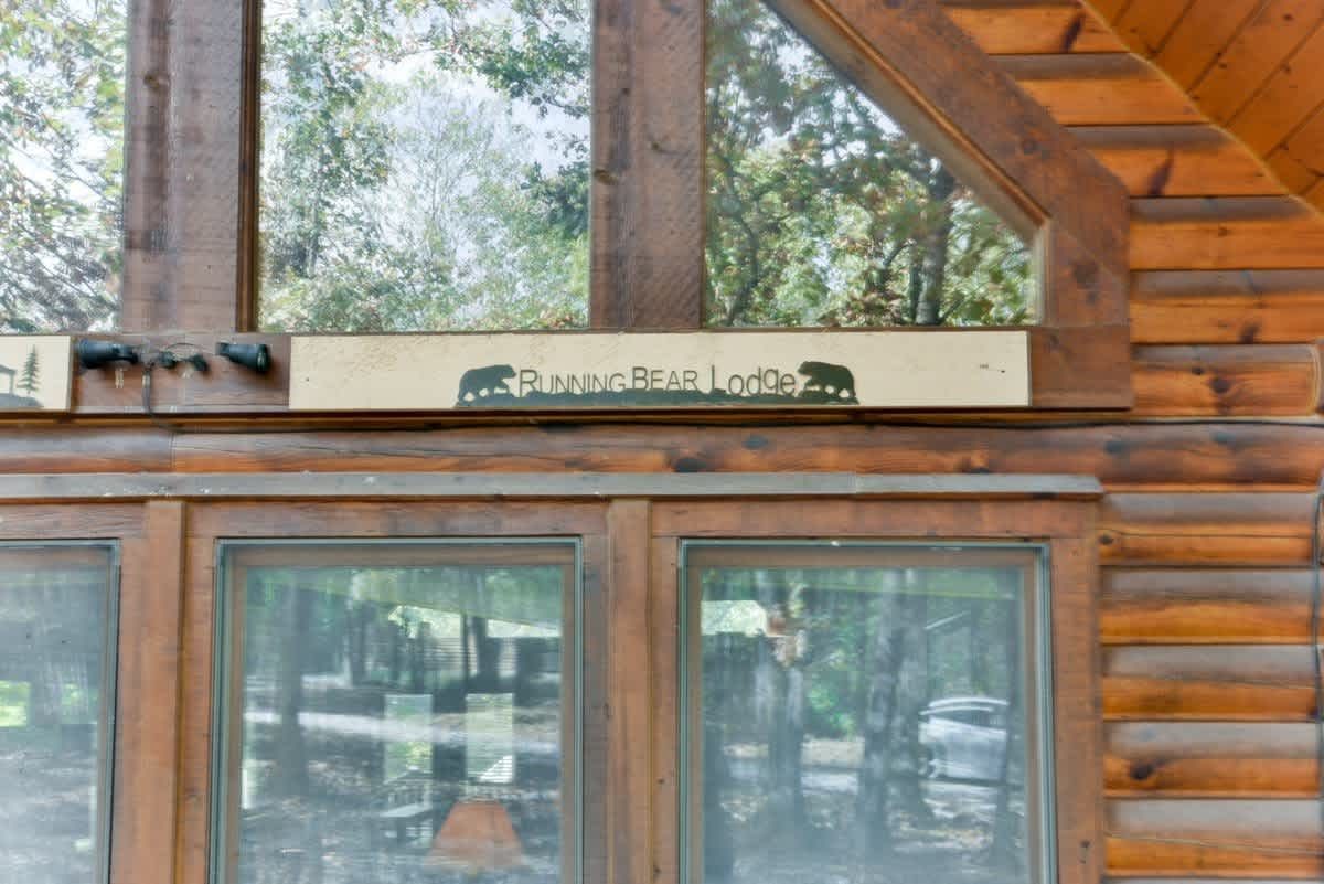 A log cabin with a large window and a sign above it.