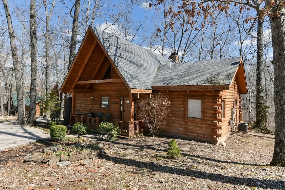 A small log cabin in the middle of a forest.