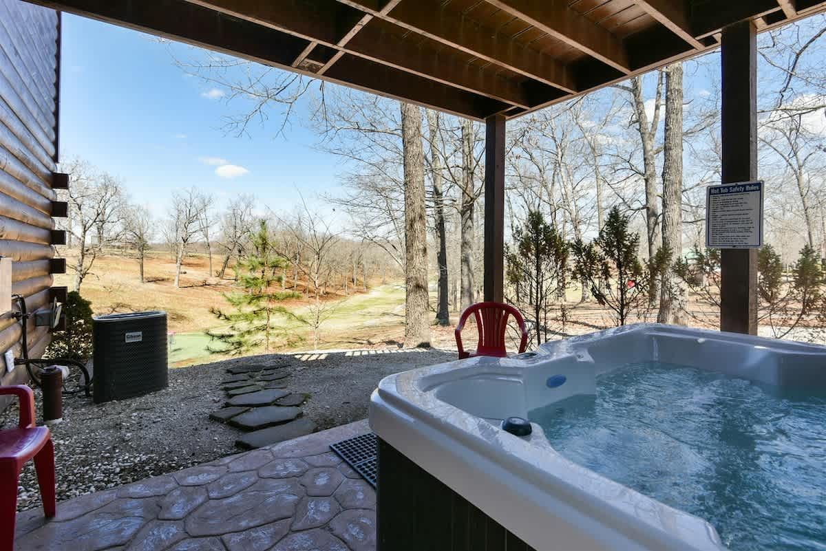 There is a hot tub on the porch of a house.