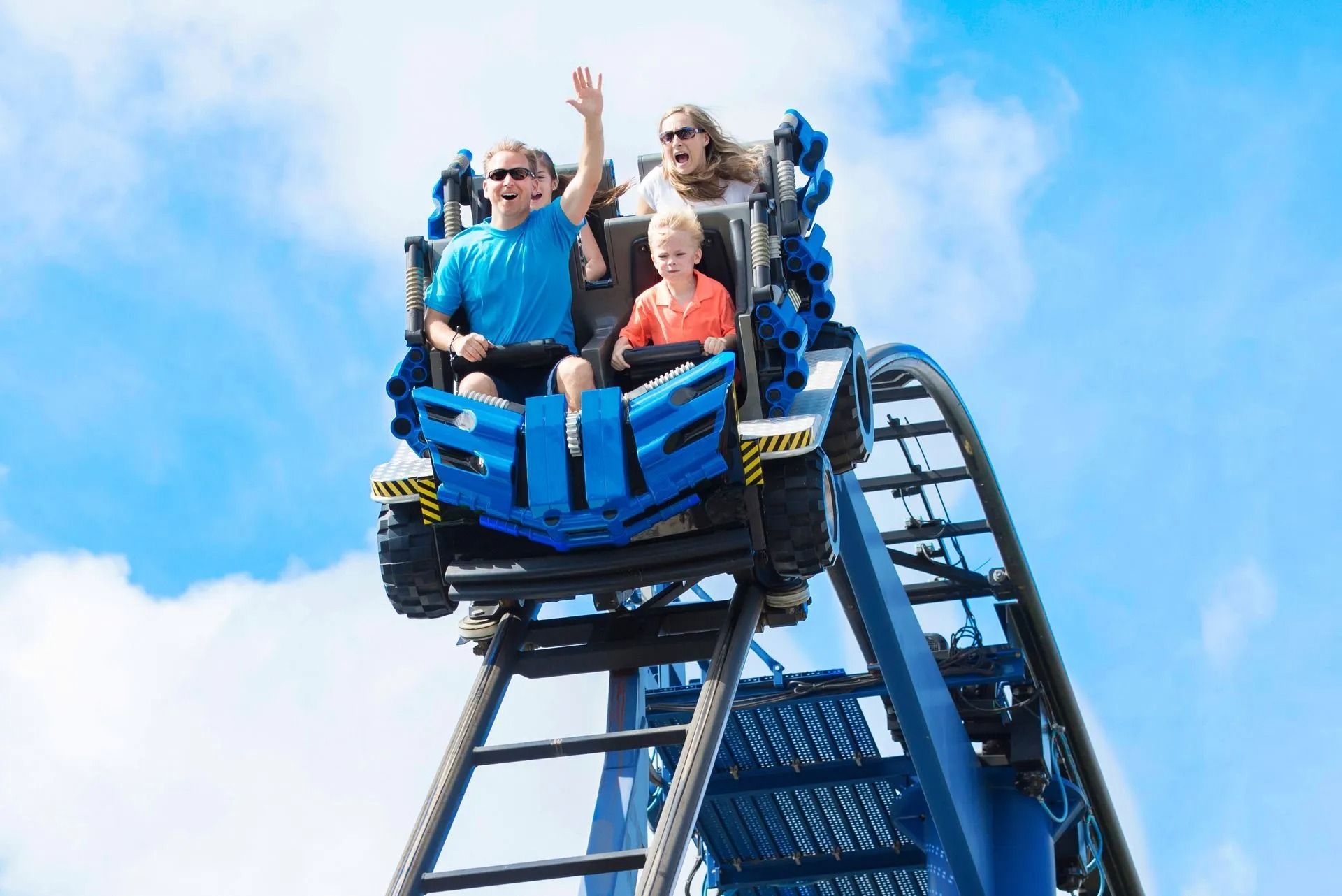 A family is riding a roller coaster at an amusement park.