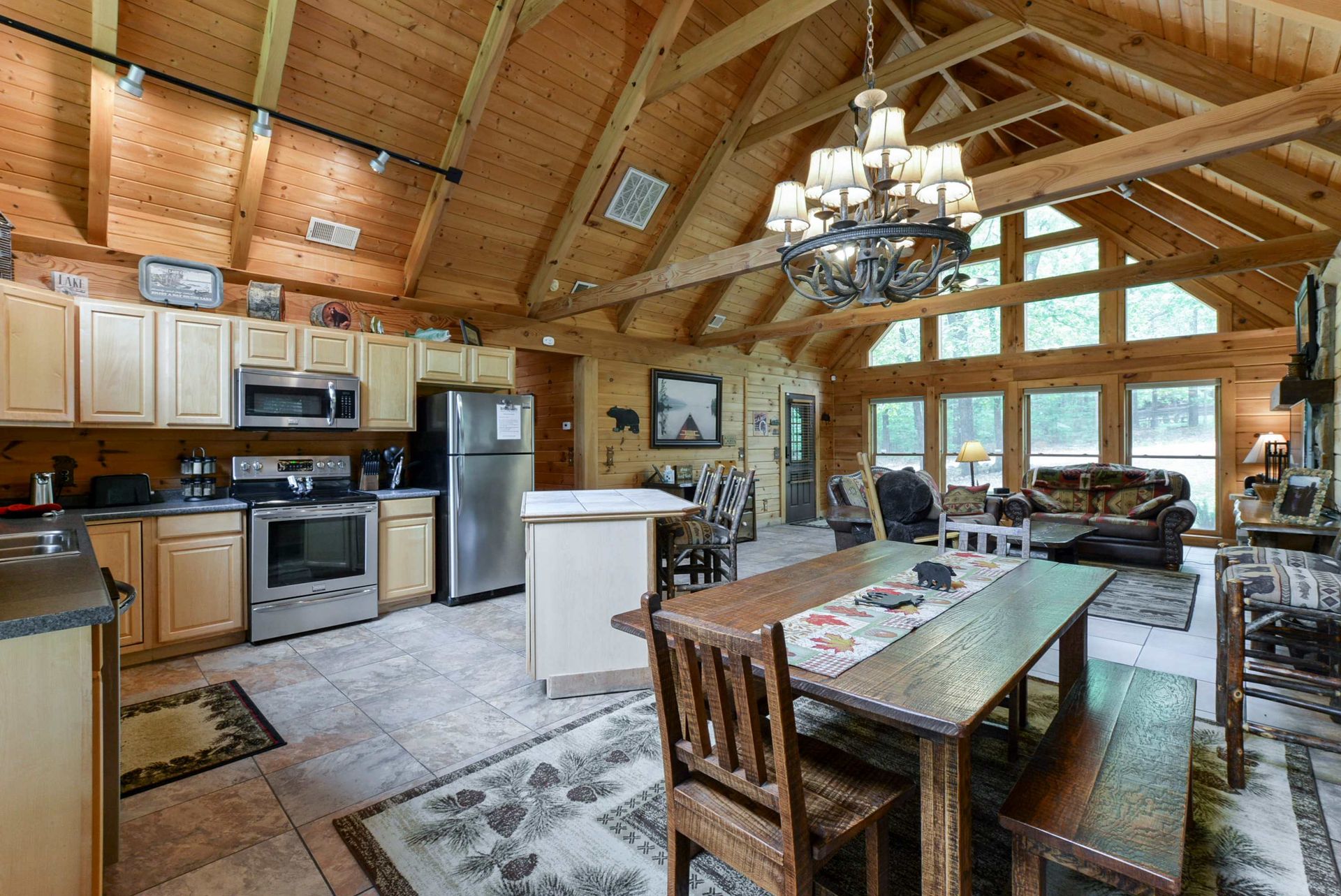 A kitchen , dining room and living room in a log cabin.