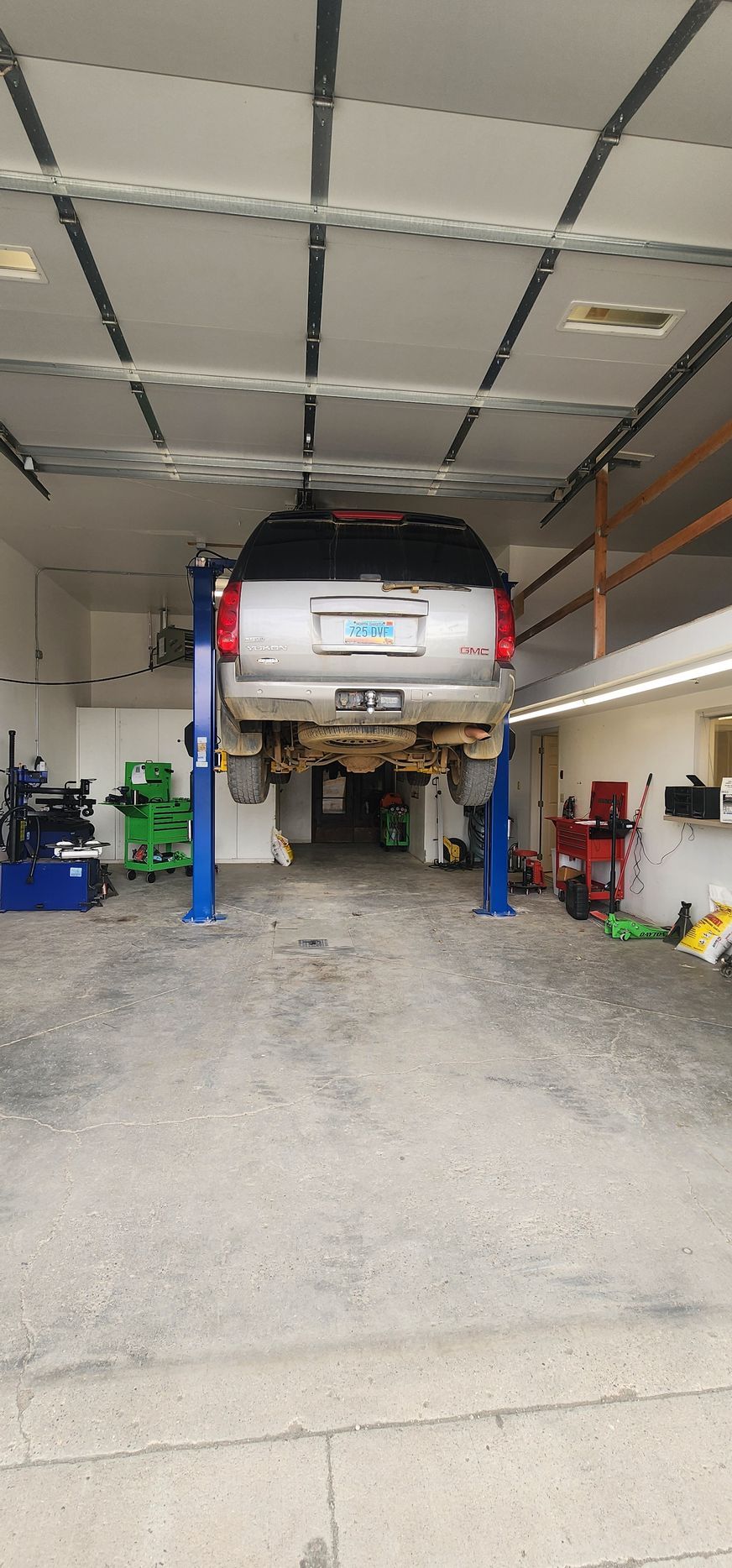 A car is sitting on a lift in a garage.