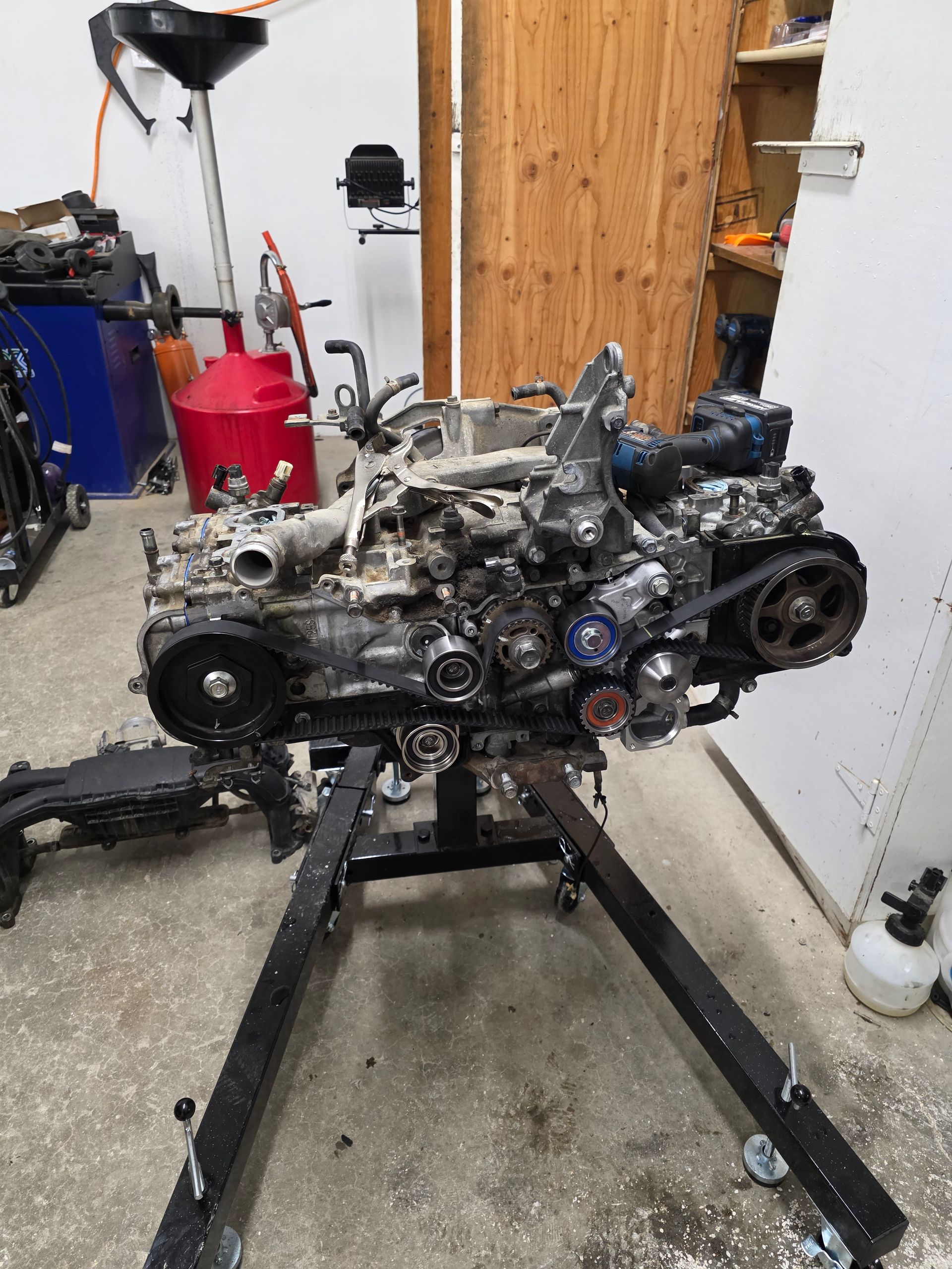 A car engine is sitting on a stand in a garage