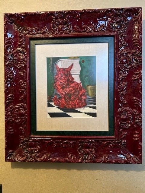 Framed artwork of a red dress on a checkered floor against a teal background.
